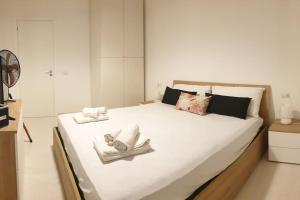 una camera da letto con un grande letto bianco con asciugamani di RgB_Apartments a Lampedusa