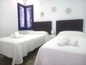 two beds in a room with white sheets and towels at Los Barqueros 25 by Best Holidays Fuerteventura in Corralejo