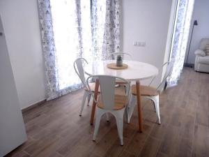 a white table and chairs in a room at Los Barqueros 25 by Best Holidays Fuerteventura in Corralejo