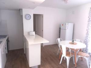 a white kitchen with a table and a white refrigerator at Los Barqueros 25 by Best Holidays Fuerteventura in Corralejo