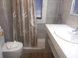 a bathroom with a toilet and a shower curtain at Los Barqueros 25 by Best Holidays Fuerteventura in Corralejo