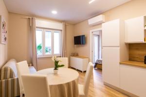 ディアーノ・マリーナにあるAppartamento SEAのテーブルと椅子のあるキッチンとダイニングルーム +3枚の写真