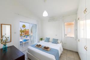 a bedroom with two beds and a table and a balcony at Fig Tree Bay Villa 3 in Protaras +66 photos