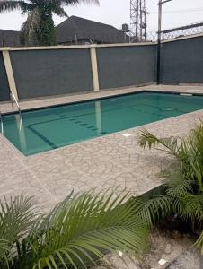 una piscina in una casa con pavimento piastrellato di Zucchini Hotel and apartments a Umueme