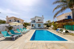 a villa with a swimming pool and blue chairs at Fig Tree Bay Villa 3 in Protaras