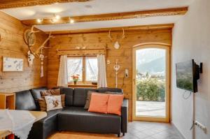 a living room with a black couch and a window at Ferienhaus Veronika mit 2000qm Garten und Bergblick in Unterammergau