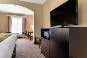 a hotel room with a bed and a flat screen tv at Comfort Inn & Suites Scott-West Lafayette in Scott