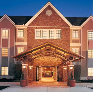 a large brick building with an archway at Sonesta ES Suites Dallas - Las Colinas in Irving