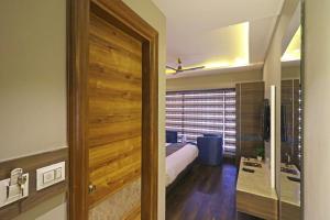 a bedroom with a bed and a wooden door at Hotel The IVY Grand With Free Secured Parking in New Delhi