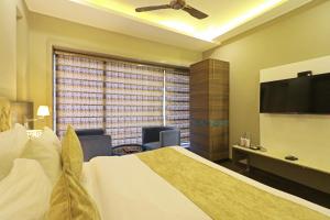 Habitación de hotel con cama y TV de pantalla plana. en Hotel The IVY Grand With Free Secured Parking, en Nueva Delhi