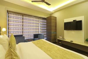 a hotel room with a bed and a flat screen tv at Hotel The IVY Grand With Free Secured Parking in New Delhi