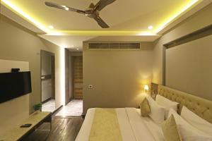 a bedroom with a bed with a ceiling fan at Hotel The IVY Grand With Free Secured Parking in New Delhi