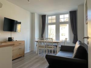 ein Wohnzimmer mit einem Sofa und einem Tisch in der Unterkunft Office Apartment zentral zur Dortmunder Innenstadt in Dortmund