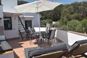 a patio with a table and chairs and an umbrella at Balcó de Tamariu in Tamariu