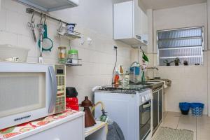 a small kitchen with a stove and a microwave at cantinho jardim in Santos