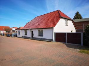 a white house with a red roof on a brick road at Ferienwohnung Alte Schmiede in Niepars
