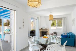 a dining room with a glass table and white chairs at Fig Tree Bay Villa 4 in Protaras