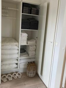 um armário branco com toalhas e uma pilha de toalhas em Villa Pyhäjärvi em Tampere