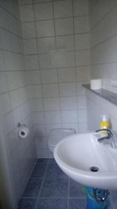 a white bathroom with a sink and a toilet at Ferienwohnung am Uferpark Blaser kleines Appartment F3 in Friedrichshafen