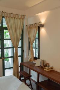 a bedroom with a desk and a bed and windows at Big Tree Boutique Hotel in Ko Tao