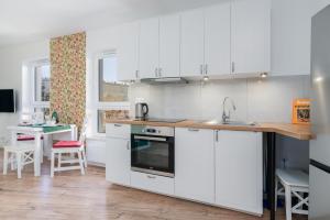 a kitchen with white cabinets and a counter top at Rezydencja Rejtana with FREE GARAGE Poznań by Renters in Poznań