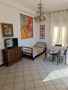 - une chambre avec un lit, une table et une télévision dans l'établissement Maia Incantevole, à Levanto