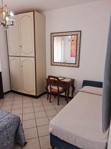 - une chambre avec 2 lits, un miroir et une chaise dans l'établissement Maia Incantevole, à Levanto