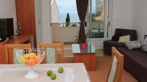 een woonkamer met een tafel met een fruitschaal erop bij Apartmani Abesinac in Makarska