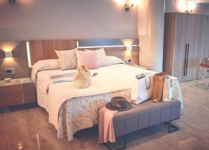 a bedroom with a large bed with a hat on a bench at Hotel Nueva Plaza in Maliaño