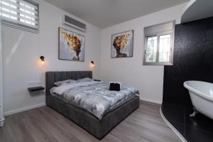 a bedroom with a bed and a tub and a sink at Luxury Room Bahai's Garden in Haifa