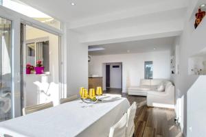 uma sala de jantar branca com uma mesa e cadeiras brancas em Luxury apartment Martinis with pool em Split