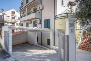 a white building with a gate and a balcony at Luxury apartment Martinis with pool in Split