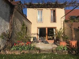 a house with a patio and flowers in the yard at Ferienapartments im Hintergässel in Sankt Martin
