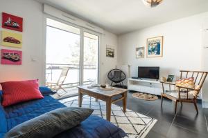 uma sala de estar com um sofá azul e uma mesa em CABANA & Le Manoir - Proche du Lac em Annecy