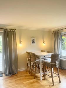 a dining room with a white table and chairs at Landhaus am Wald mit Garten mit 1 Schlafnische und 1 Schlafzimmer in Aurich