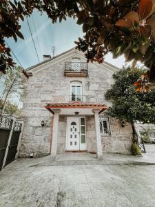 uma grande casa de pedra com uma porta branca em Pazo Dos Remedios em Ponteareas