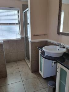 a bathroom with a white sink and a shower at Clarens Villas in Clarens