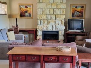 a living room with a couch and a fireplace at Clarens Villas in Clarens