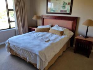 a bedroom with a large bed with blue sheets and pillows at Clarens Villas in Clarens