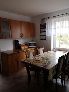 uma cozinha com uma mesa com cadeiras e um micro-ondas em Pokój przy jeziorze em Wiżajny