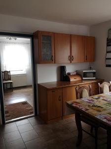 a kitchen with wooden cabinets and a table and a dining room at Pokój przy jeziorze in Wiżajny