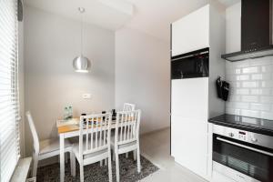 a kitchen with a table and chairs and a microwave at Bartycka Elegant Apartment in Warsaw