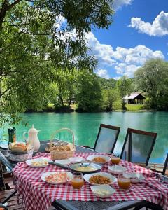 a table with food and a view of a river at River Luxury House in Bihać