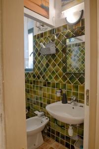 a bathroom with a sink and a toilet and a mirror at La casetta al centro di Olbia in Olbia