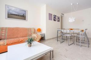 un soggiorno con divano e tavolo di Residencial Tamarindo - Primera línea Gran terraza a Denia