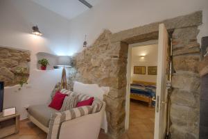 a living room with a stone wall and a couch at La casetta al centro di Olbia in Olbia