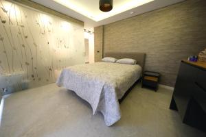 Un dormitorio con una cama grande y una pared en Sky Garden Suites, en Adana