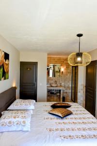 a bedroom with a large bed and a chandelier at Chambre d'hôtes Cottes in Callian