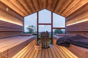 a sauna with a bed and a large window at Winzarei, Weingut Tement in Berghausen