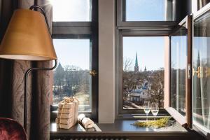 a table with a lamp and a window with a view at Grand Poet Hotel and SPA by Semarah in Rīga
